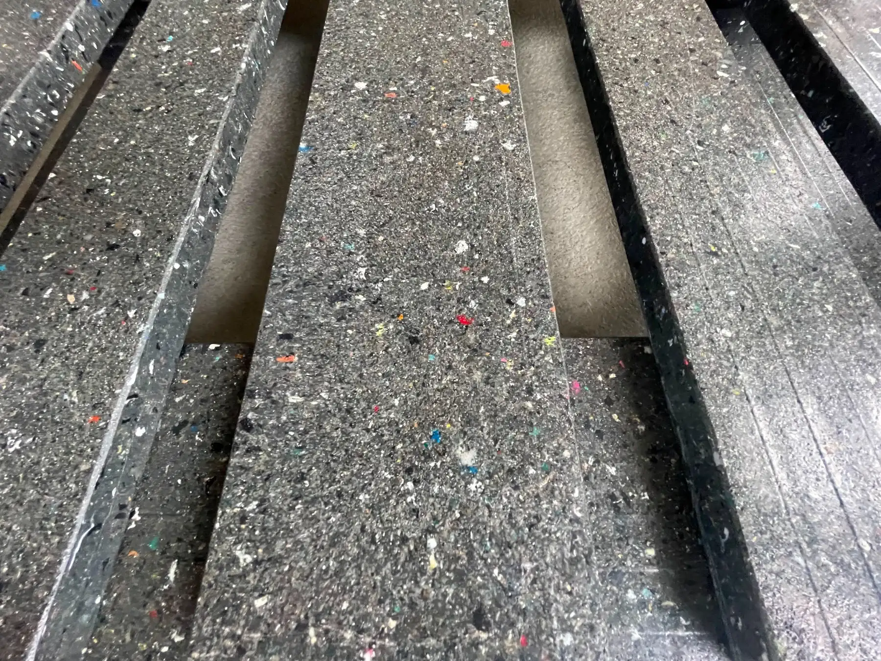 Close-up photograph of the textured deck and parallel openings of a development pallet
